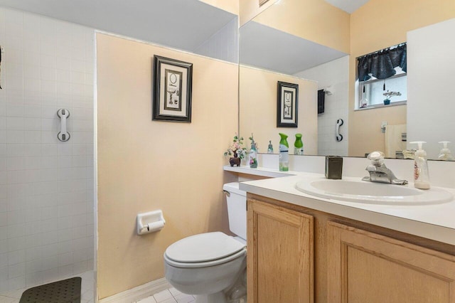 bathroom with vanity, tile patterned floors, toilet, and a tile shower