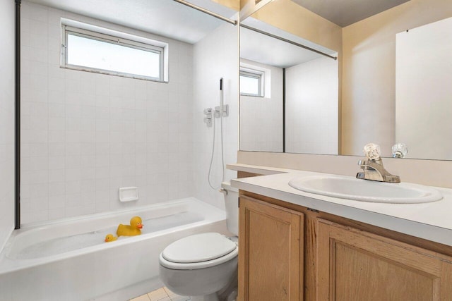 full bathroom featuring tiled shower / bath, vanity, tile patterned floors, and toilet