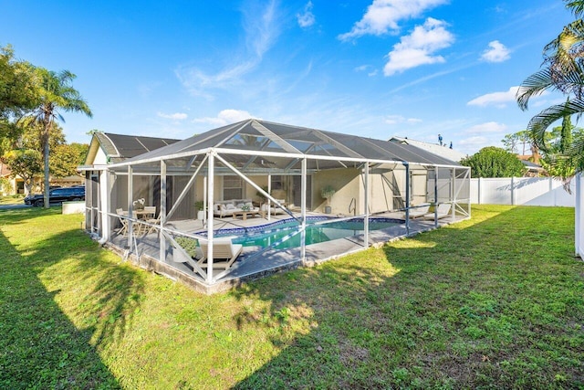 rear view of house with a patio, a yard, a fenced in pool, and glass enclosure