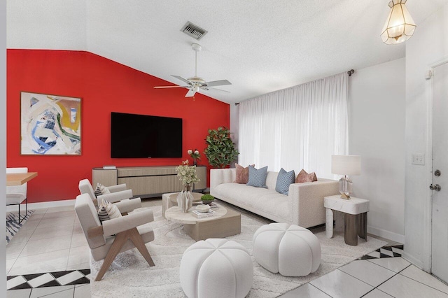 tiled living room featuring ceiling fan, lofted ceiling, and a textured ceiling