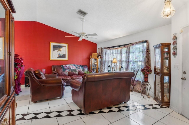 living room featuring lofted ceiling, ceiling fan, light tile patterned floors, and a textured ceiling