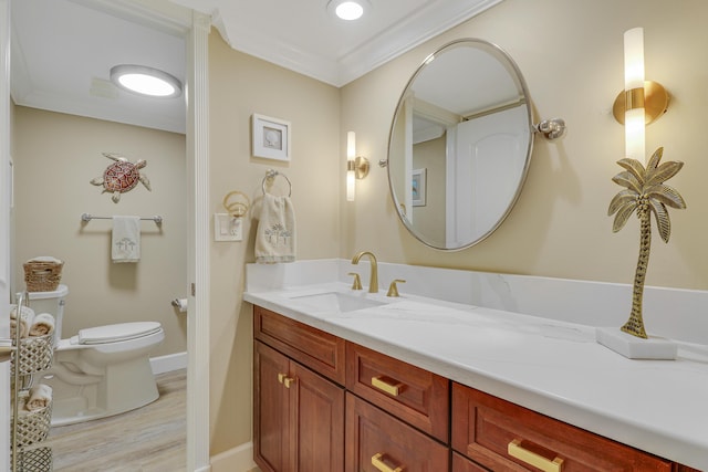 bathroom featuring ornamental molding, hardwood / wood-style floors, vanity, and toilet