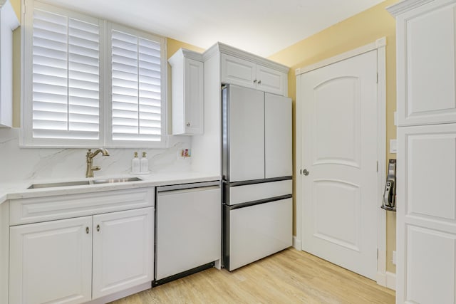 kitchen featuring sink, fridge, dishwasher, light hardwood / wood-style floors, and white cabinets