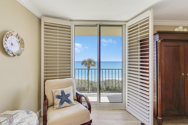 sitting room featuring a water view, floor to ceiling windows, crown molding, and light hardwood / wood-style flooring