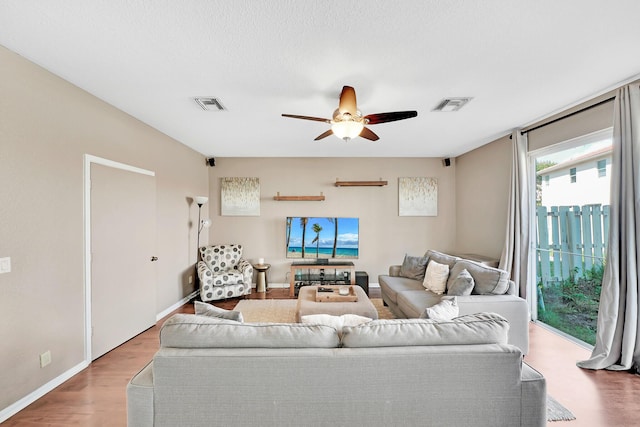 living room featuring wood-type flooring and ceiling fan