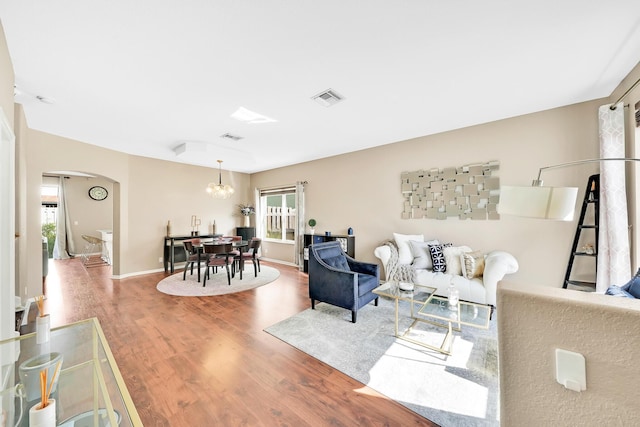 living room featuring an inviting chandelier and wood-type flooring