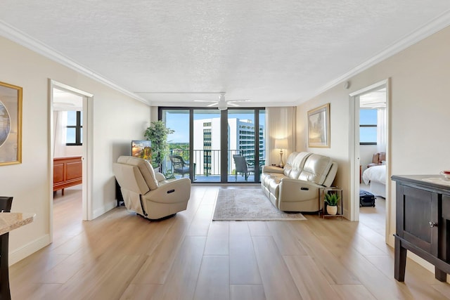 living room featuring light hardwood / wood-style flooring, ceiling fan, floor to ceiling windows, ornamental molding, and a textured ceiling