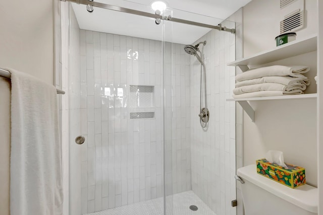 bathroom featuring toilet and a tile shower