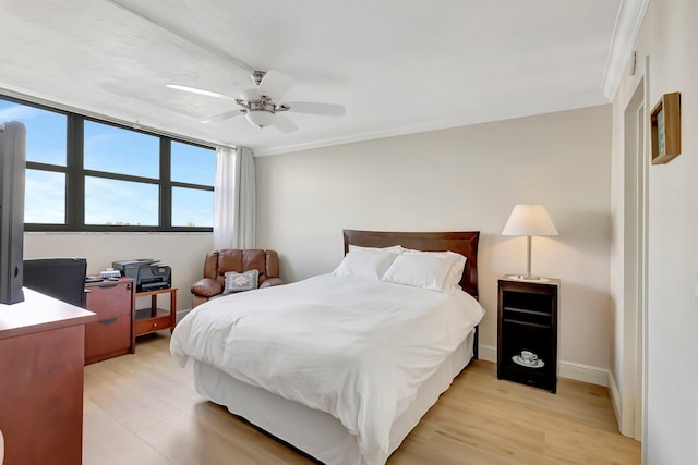 bedroom featuring crown molding, light hardwood / wood-style floors, and ceiling fan