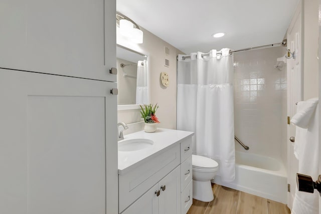 full bathroom with shower / bathtub combination with curtain, vanity, hardwood / wood-style floors, and toilet