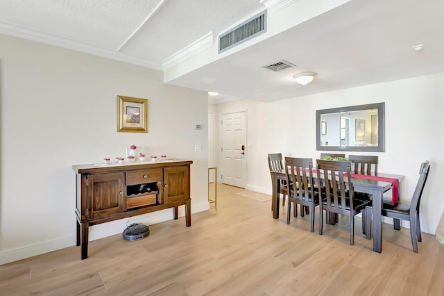 dining space featuring light hardwood / wood-style flooring and ornamental molding