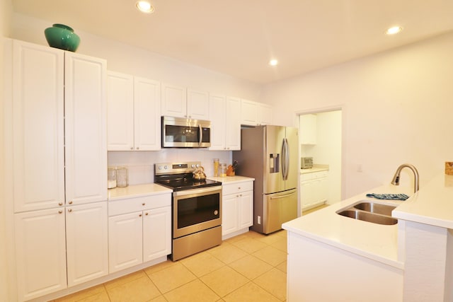 kitchen with white cabinetry, sink, light tile patterned floors, and stainless steel appliances