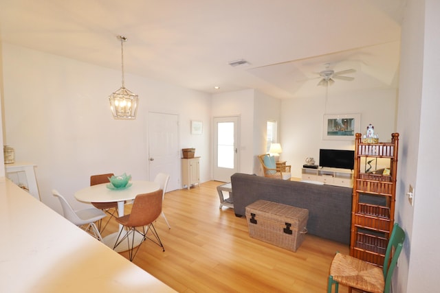 interior space with wood-type flooring and ceiling fan with notable chandelier