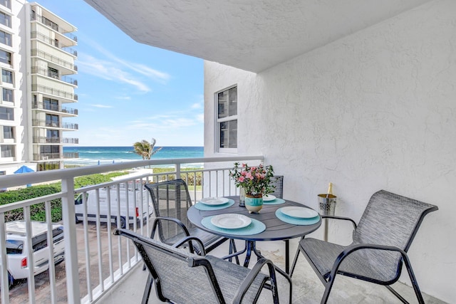 balcony with a water view and a beach view