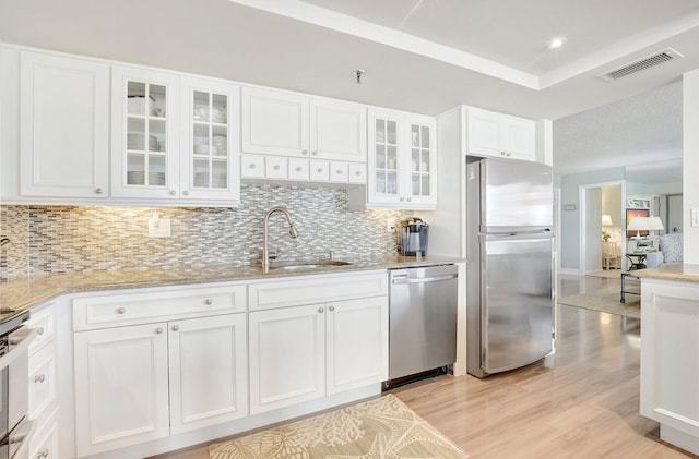 kitchen featuring white cabinetry, sink, decorative backsplash, and appliances with stainless steel finishes