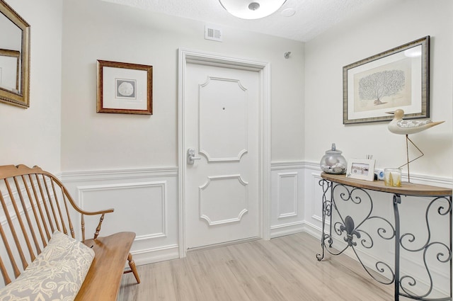 foyer with light hardwood / wood-style flooring and a textured ceiling