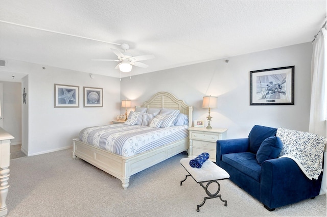 carpeted bedroom with ceiling fan and a textured ceiling