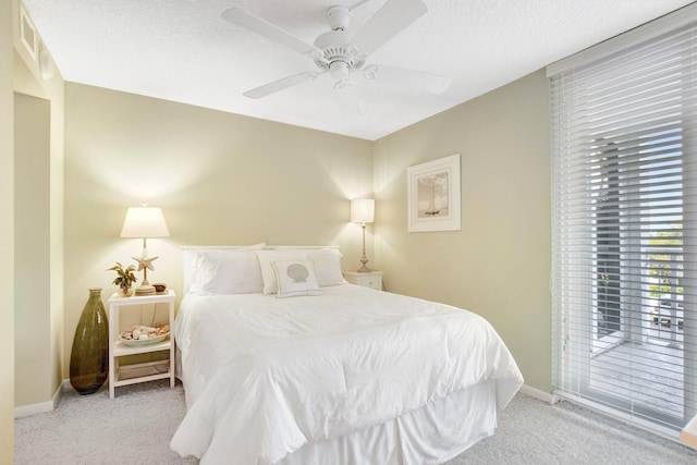 carpeted bedroom with access to exterior, a textured ceiling, and ceiling fan