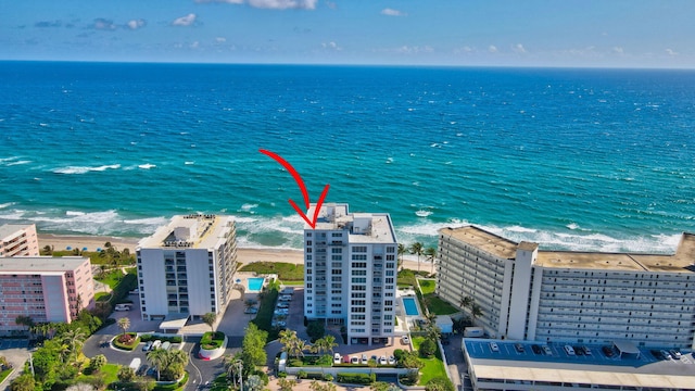 birds eye view of property featuring a water view and a beach view