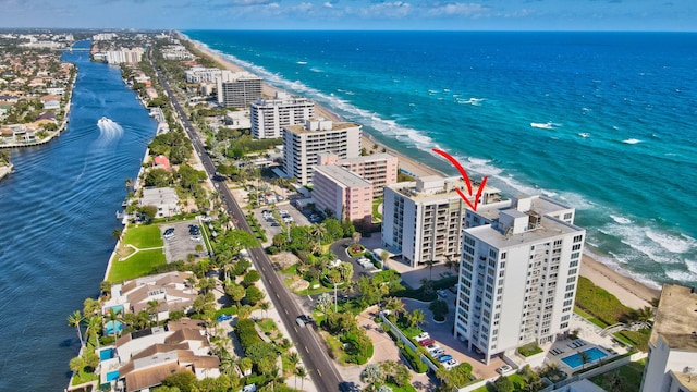 drone / aerial view with a water view and a beach view