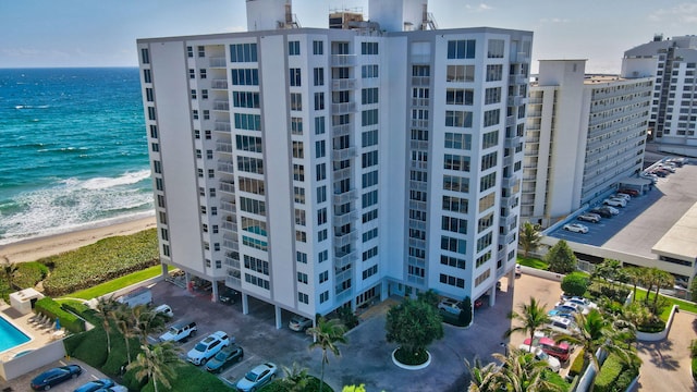 view of building exterior featuring a beach view and a water view