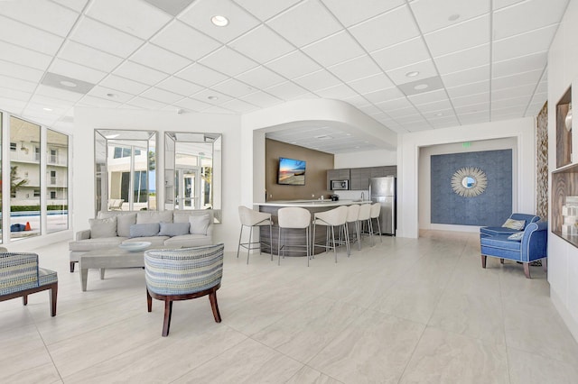 tiled living room with a drop ceiling