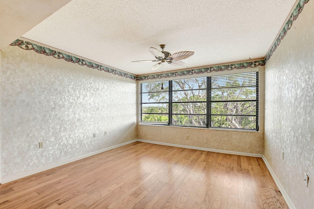 spare room with hardwood / wood-style floors, plenty of natural light, and a textured ceiling