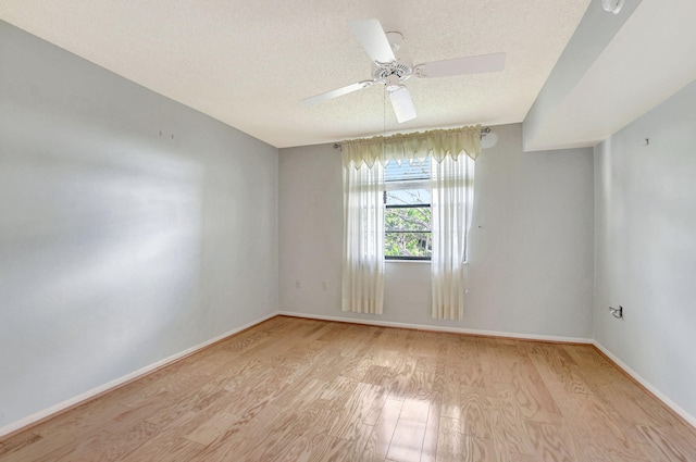 empty room with ceiling fan, a textured ceiling, and light hardwood / wood-style floors