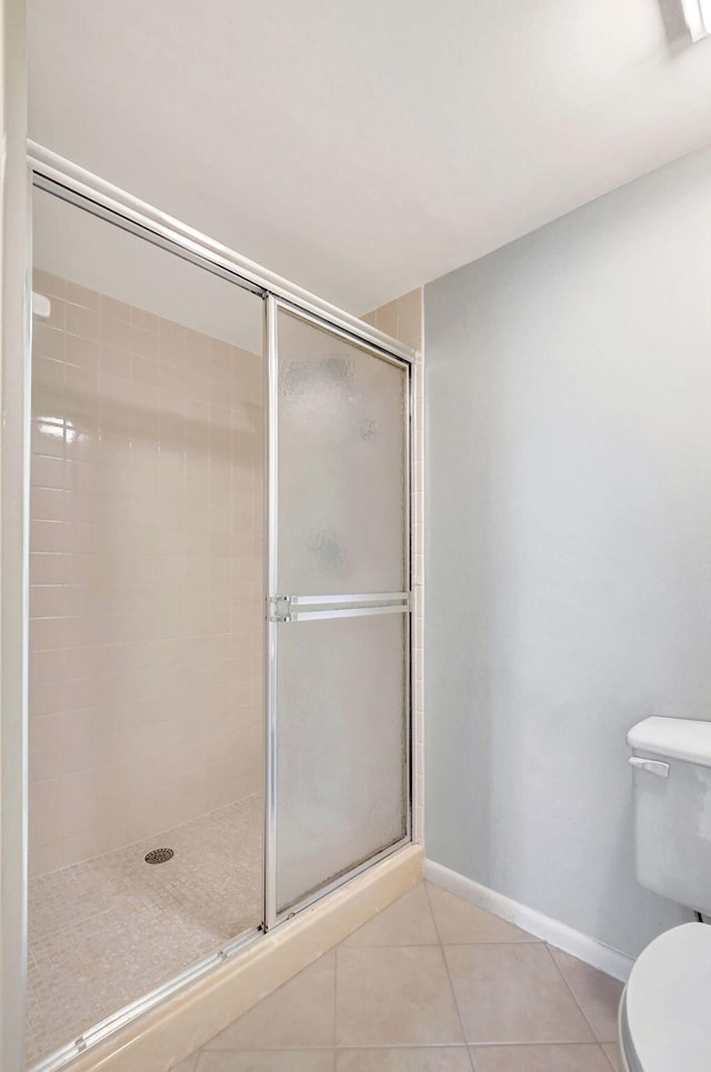 bathroom with tile patterned floors, toilet, and walk in shower