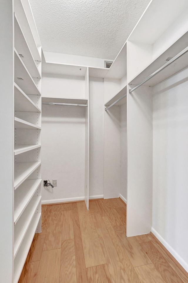 walk in closet with wood-type flooring