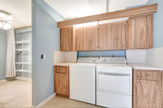 washroom featuring cabinets, light carpet, a textured ceiling, and independent washer and dryer