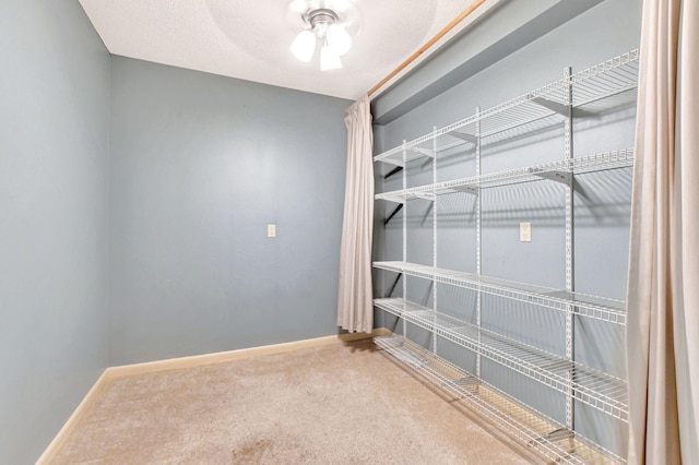 walk in closet featuring ceiling fan and carpet