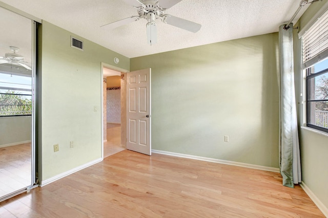 unfurnished bedroom with a closet, a textured ceiling, and light wood-type flooring