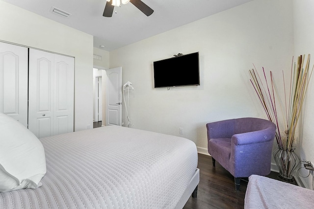 bedroom with dark hardwood / wood-style flooring, a closet, and ceiling fan