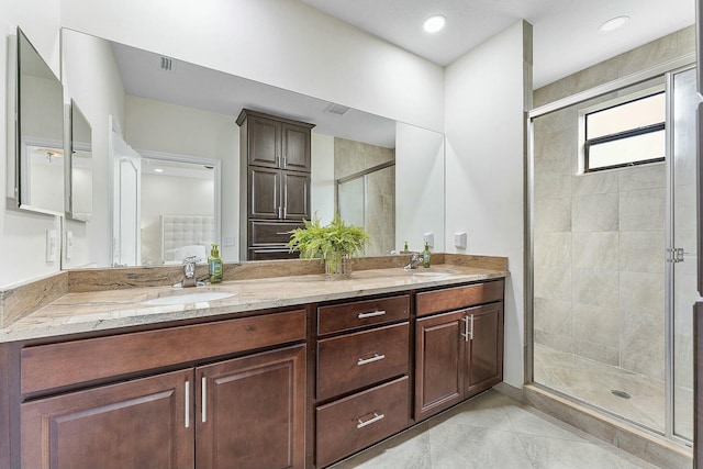 bathroom with tile patterned floors, vanity, and an enclosed shower