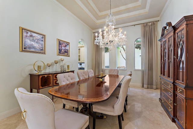 dining area featuring ornamental molding, an inviting chandelier, and a tray ceiling