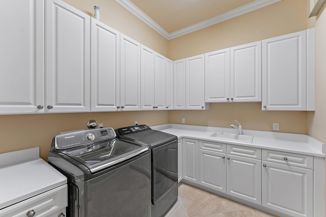 washroom with cabinets, ornamental molding, sink, and washing machine and dryer