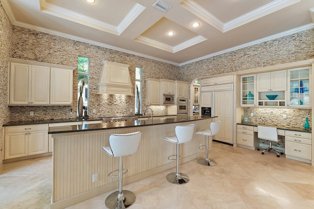 kitchen with tasteful backsplash, a kitchen breakfast bar, a center island, built in appliances, and custom range hood