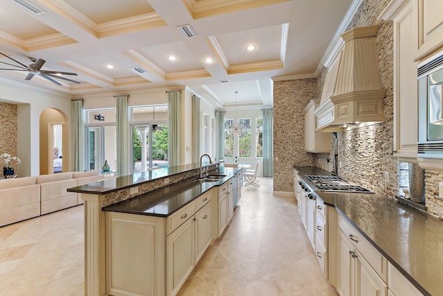 kitchen with sink, decorative backsplash, coffered ceiling, ceiling fan, and cream cabinetry