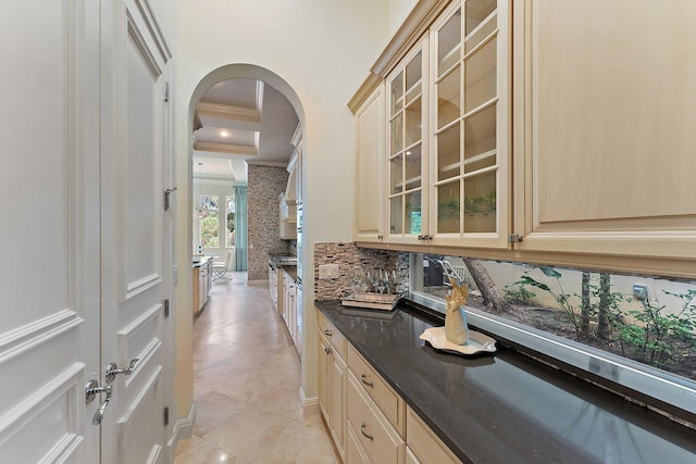 bar featuring tasteful backsplash, crown molding, light brown cabinetry, and dark stone counters