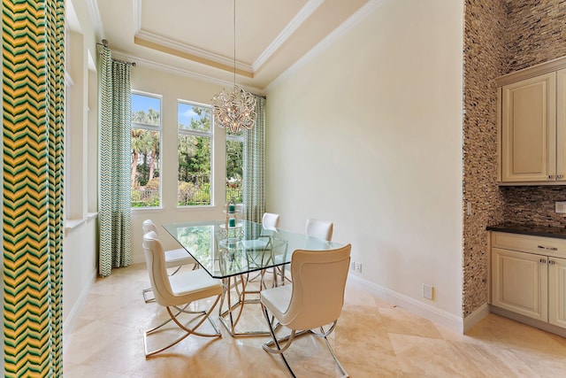 tiled dining space with crown molding, a raised ceiling, and a chandelier