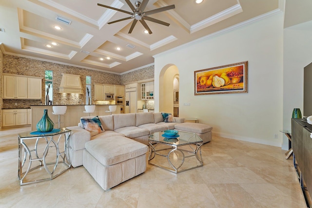 living room with ornamental molding, coffered ceiling, ceiling fan, and beam ceiling