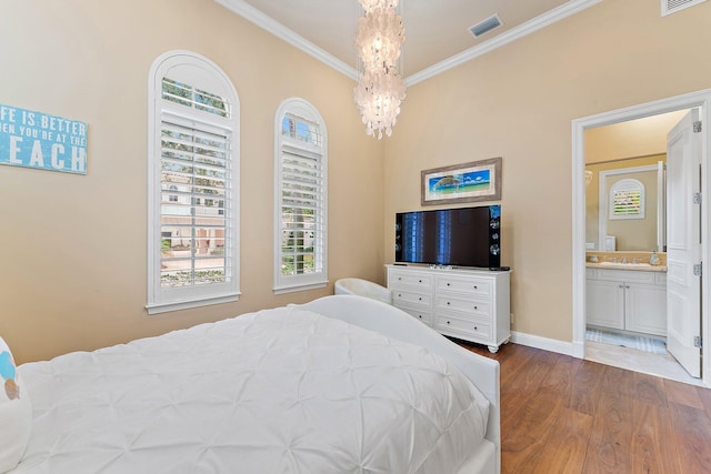 bedroom featuring ornamental molding, wood-type flooring, a chandelier, and ensuite bath