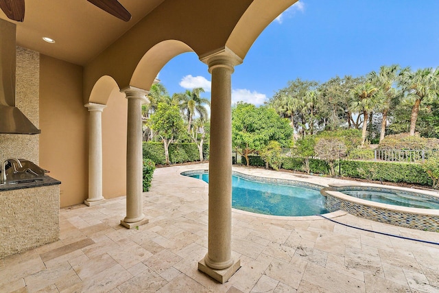 view of swimming pool with sink, a patio area, ceiling fan, and an in ground hot tub