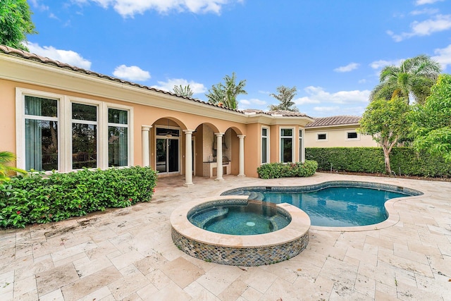 view of pool with a patio and an in ground hot tub