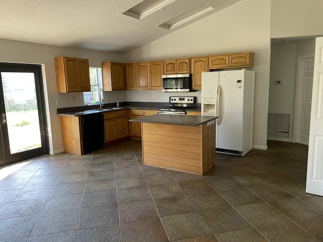 kitchen with sink, stainless steel appliances, a center island, a textured ceiling, and vaulted ceiling