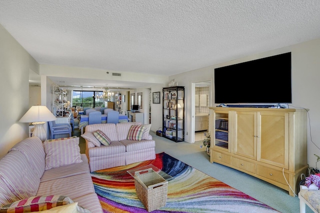 carpeted living room with a notable chandelier and a textured ceiling