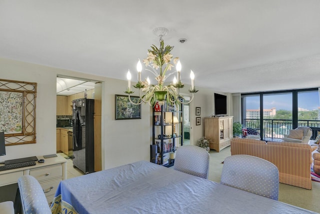 bedroom featuring black fridge, a notable chandelier, and a wall of windows