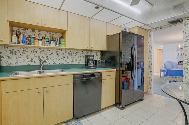 kitchen featuring sink, light tile patterned floors, light brown cabinets, and black appliances