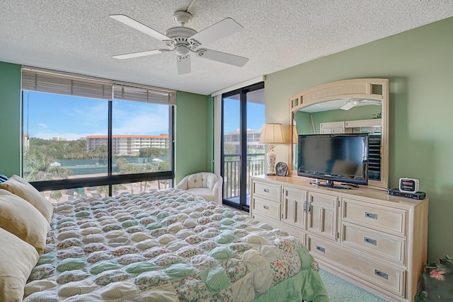 carpeted bedroom featuring access to exterior, floor to ceiling windows, a textured ceiling, and ceiling fan